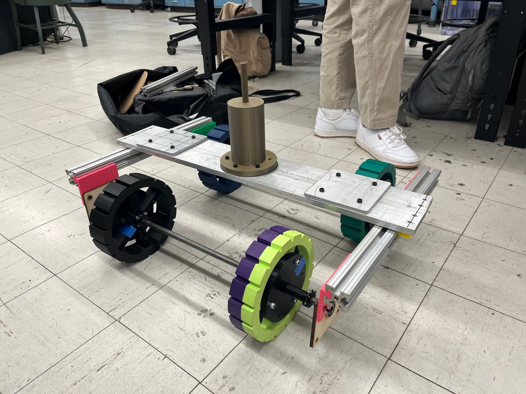 The rolling chassis prototype on the shop floor: an aluminium extrusion frame carried on four printed wheelsets.