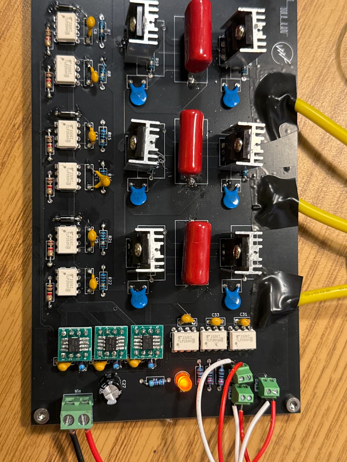 A custom-built control board populated with optocouplers, power transistors, and screw terminals.