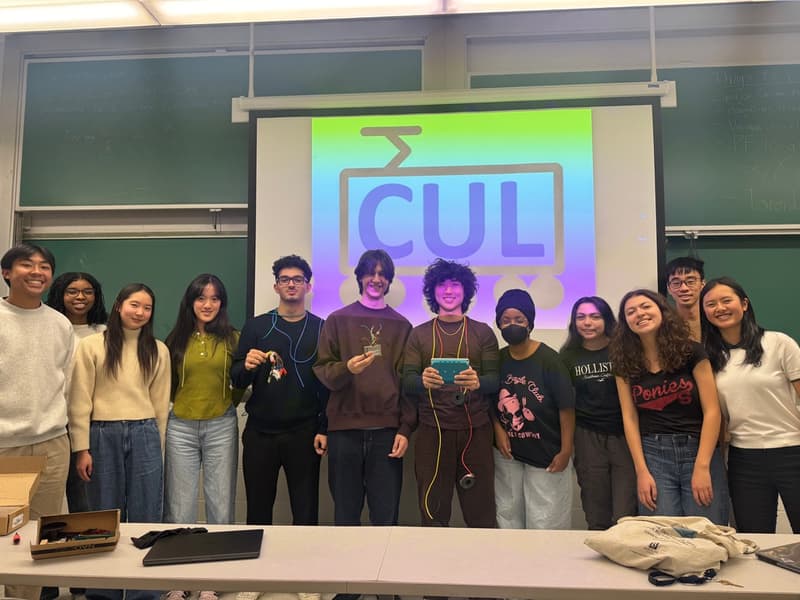 The Columbia Locomotives team gathered in a lecture room in front of the projected club logo.